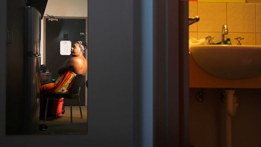 A photo of Shaniqua getting ready, as seen through a mirror in a hotel room.