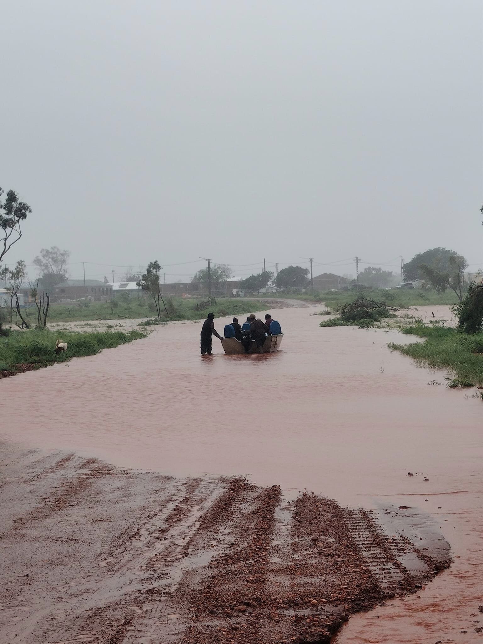 People are seen in a boat in floodwaters in the remote community of Pigeon Hole.