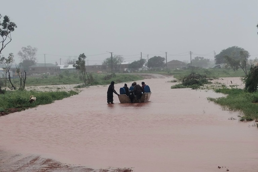 People are seen in a boat in floodwaters in the remote community of Pigeon Hole.