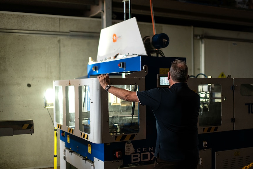 A man operating a box erecting machine.