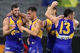 Four West Coast Eagles AFL players embrace as they celebrate a goal against Hawthorn.