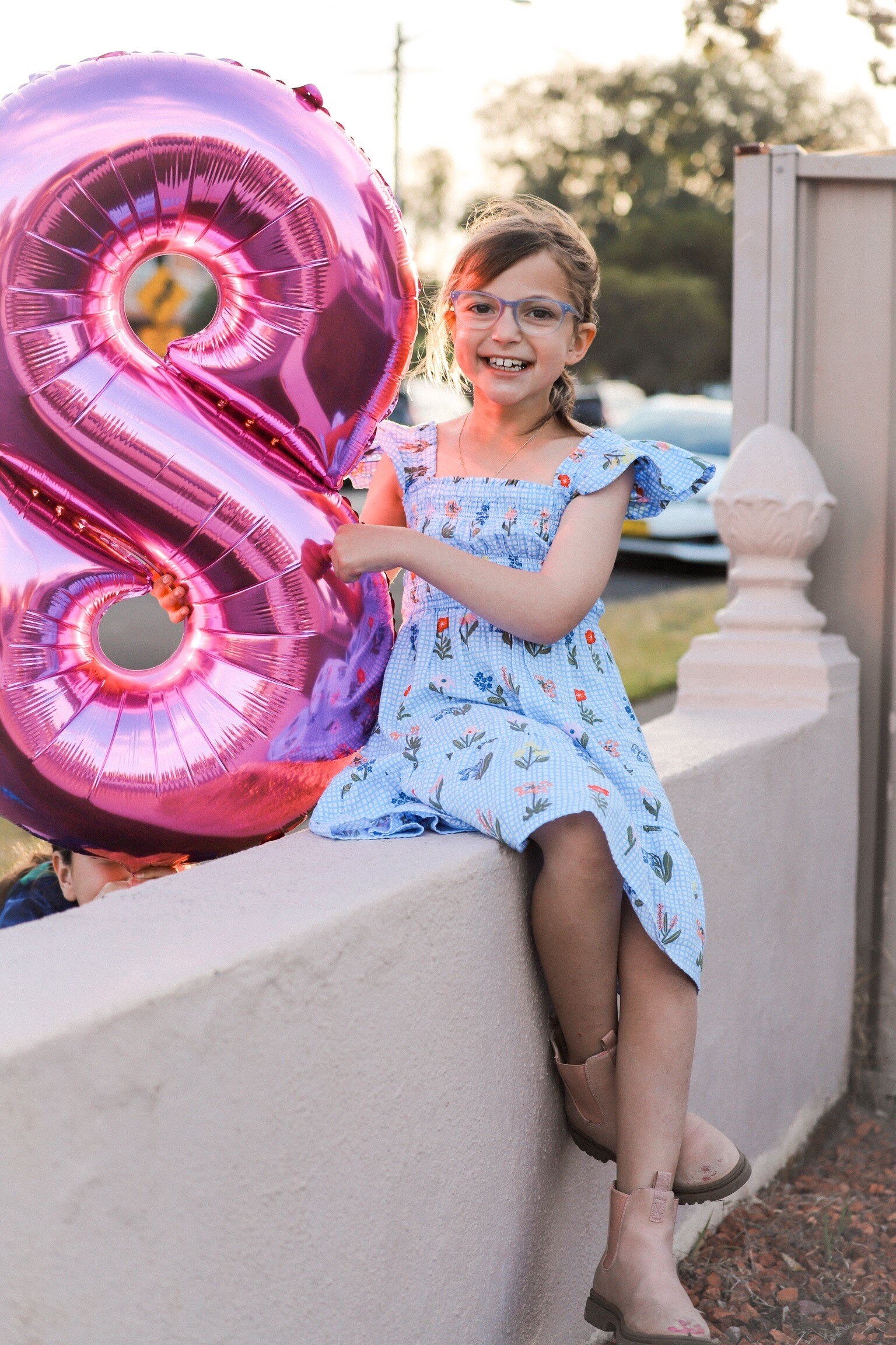 Eve Daher smiling with a balloon in the shape of the number eight.