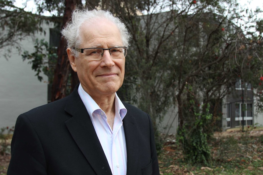 Richard Refshauge in front of some trees on an overcast day.