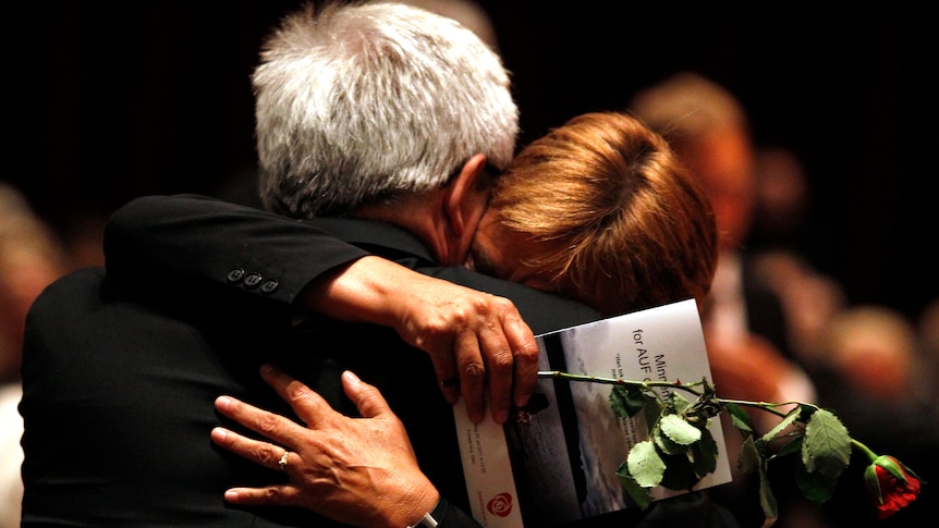 Labour Party members hug during Norway memorial