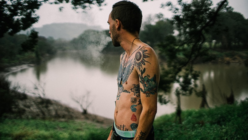 Eli in his backyard looking out over the river that flooded his home