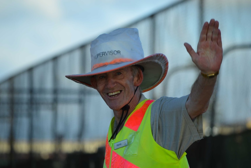 Patrick Bourke holds up his hand to stop traffic for school children.