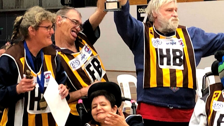 Members of the Hawks celebrate and hold the 2019 Bendigo Football League Cup aloft as they celebrate their win.