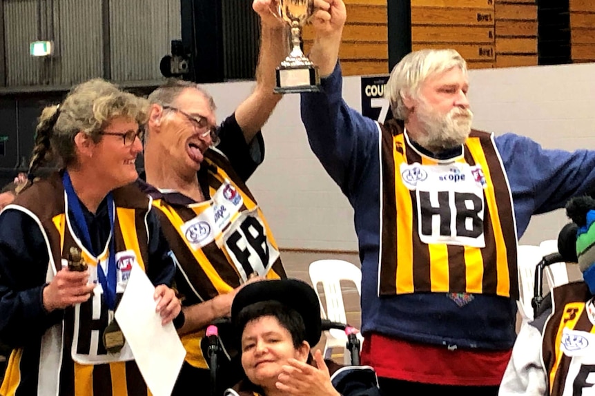 Members of the Hawks celebrate and hold the 2019 Bendigo Football League Cup aloft as they celebrate their win.