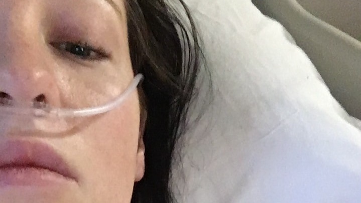 A woman in a hospital bed with a tube in her nose