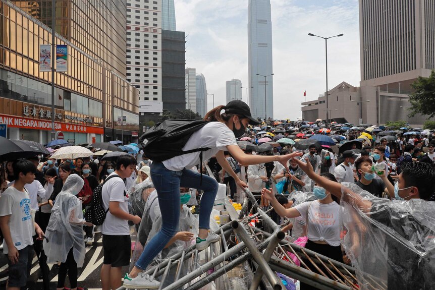 香港“反送中”集会上跨越路障的抗议人士