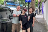 Zhang Jiayi poses for a photograph in the street with her parents. 