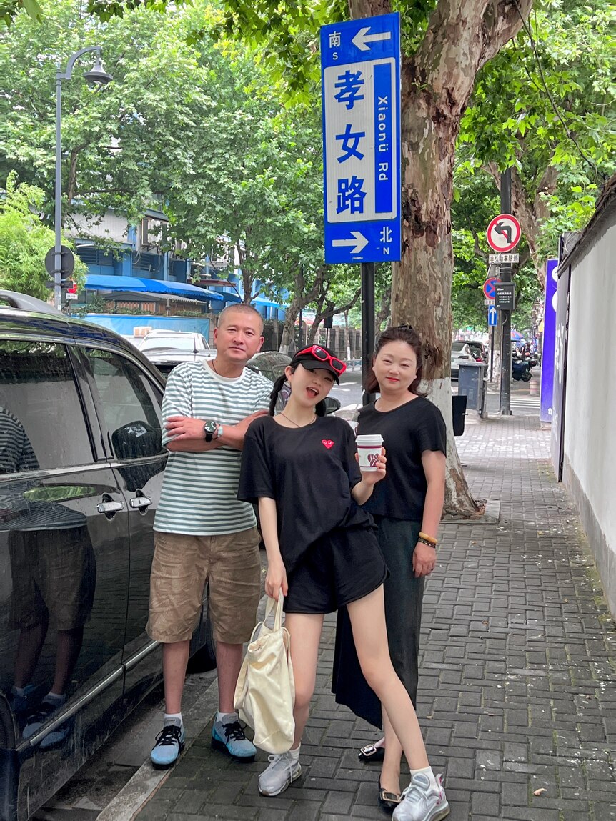 Zhang Jiayi poses for a photograph in the street with her parents. 