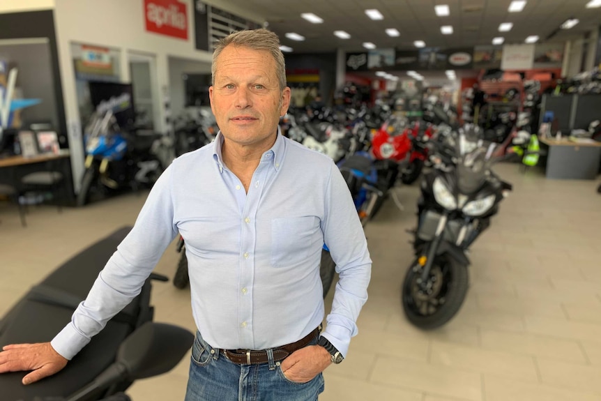 A man in a showroom of motorbikes