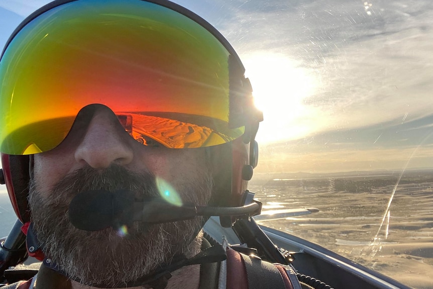 Close up of a pilot wearing a helmet in a plane