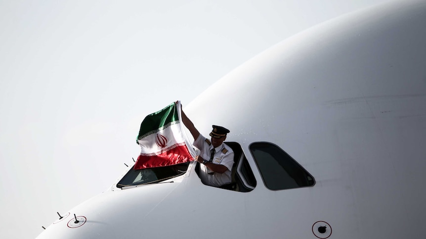 The Iranian pilot of an Airbus A380-800 aircraft holds an Iranian national flag.