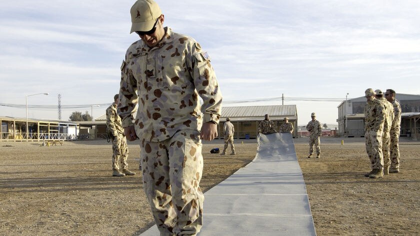 Corporal Paul Sweeney rolls out the pitch before the Boxing Day Test at Kandahar Airfield