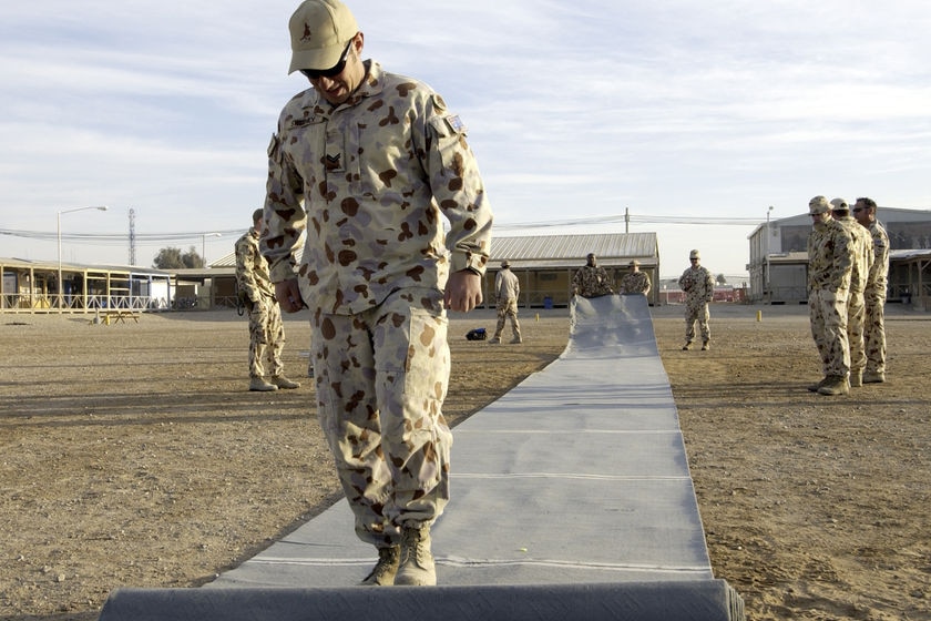 Corporal Paul Sweeney rolls out the pitch before the Boxing Day Test at Kandahar Airfield