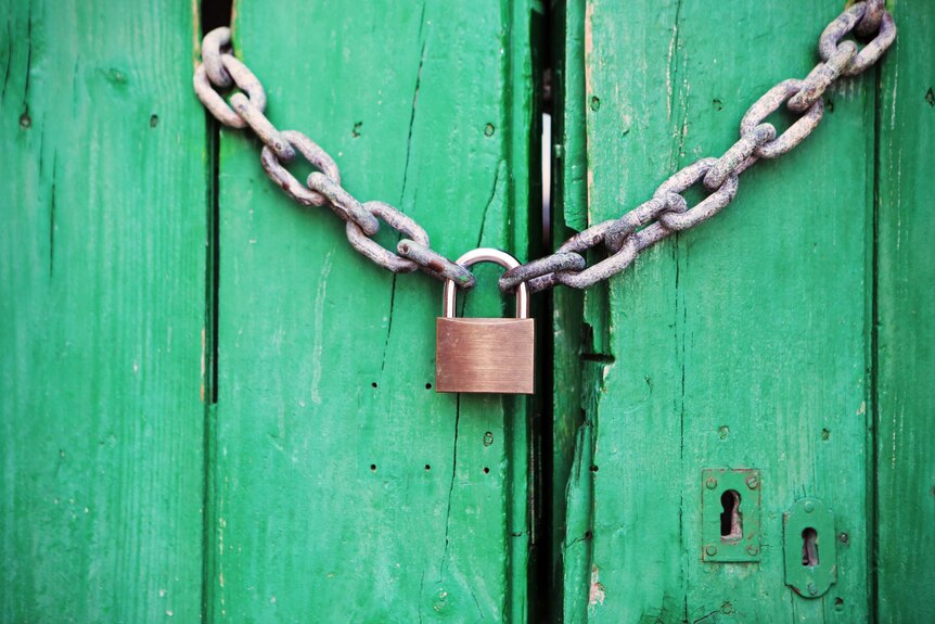Chain and lock across a green timber door