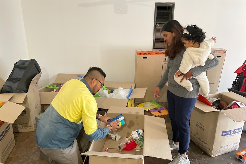 A couple unpacks moving boxes