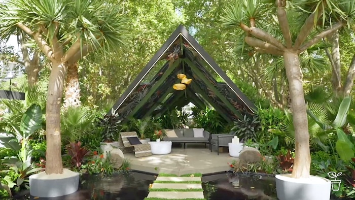 Covered outdoor area in a lush green garden.