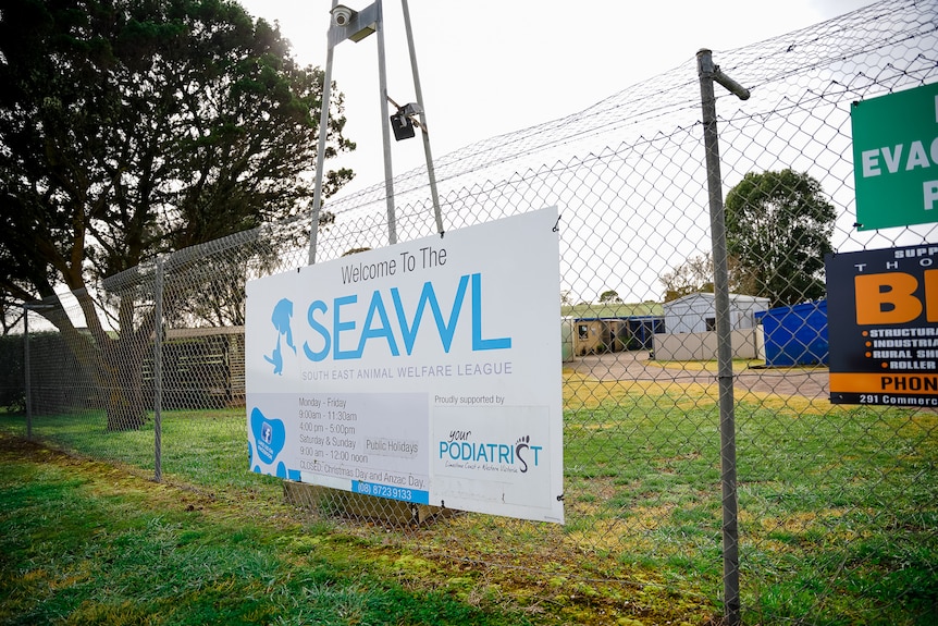 A sign against a wire fence reading: welcome to the South East Animal Welfare League
