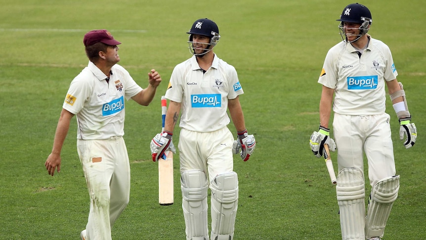 Early shower ... James Hopes (L) leaves the field with Bushrangers pair Matthew Wade and Peter Siddle during a rain interval