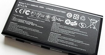 A black rectangular lithium ion battery with white writing on it.