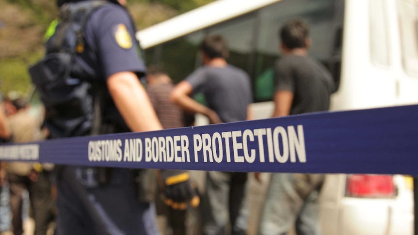Australian Customs officials escort asylum seekers
