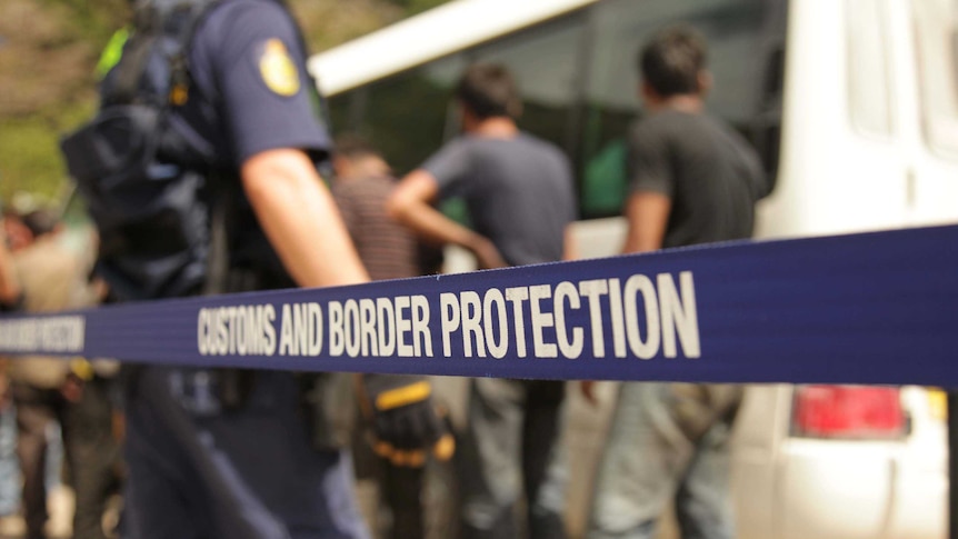 Australian Customs officials escort asylum seekers
