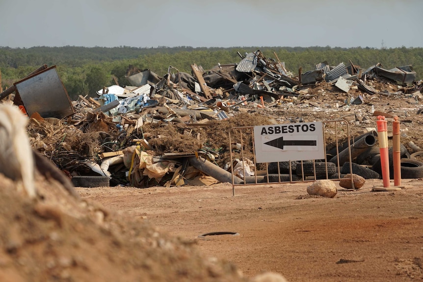A sign reading 'asbestos' points to a section at the Shoal Bay Waste Management Facility.
