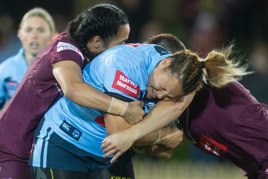 Simiana Taufa-Kautai is tackled by the Queensland defence in the women's State of Origin match.
