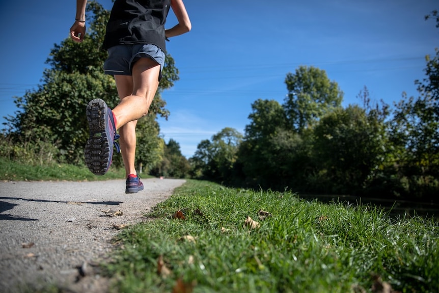 An unidentified woman runs along a footpath.