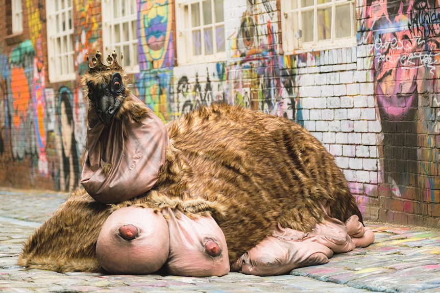 A oversized emu puppet sits in a Melbourne laneway