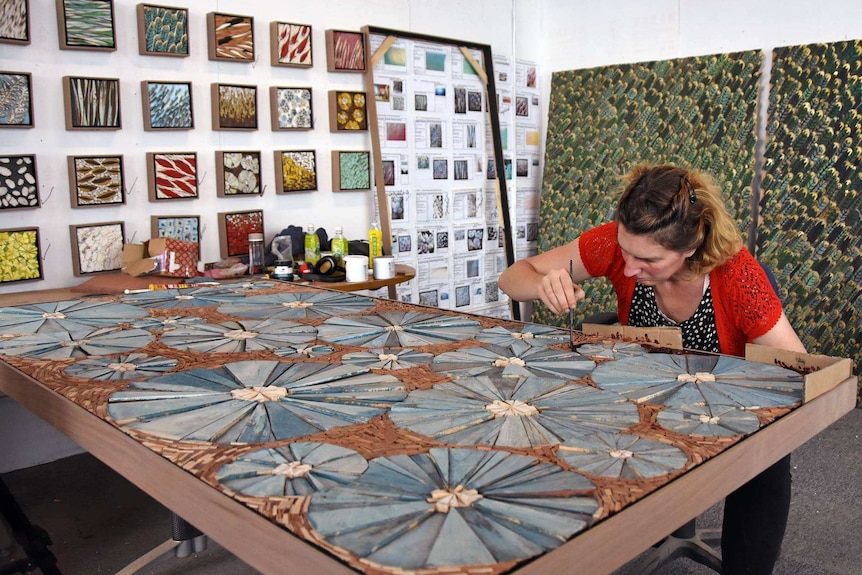 Woman works on paintings in a studio