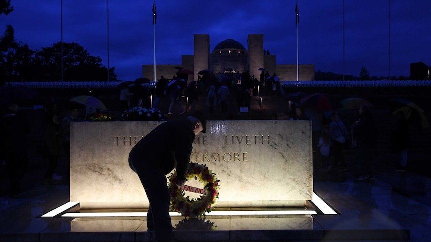 A man places a wreath at the stone of remembrance at the Australian War Memorial during dawn service on 25 April 2017.