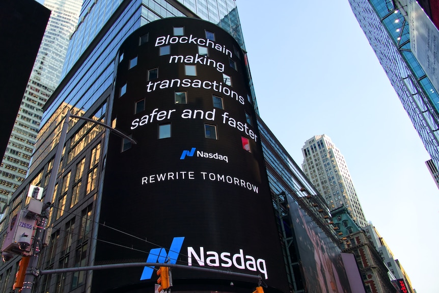 An electronic billboard in Times Square displays a Nasdaq ad about blockchain technology