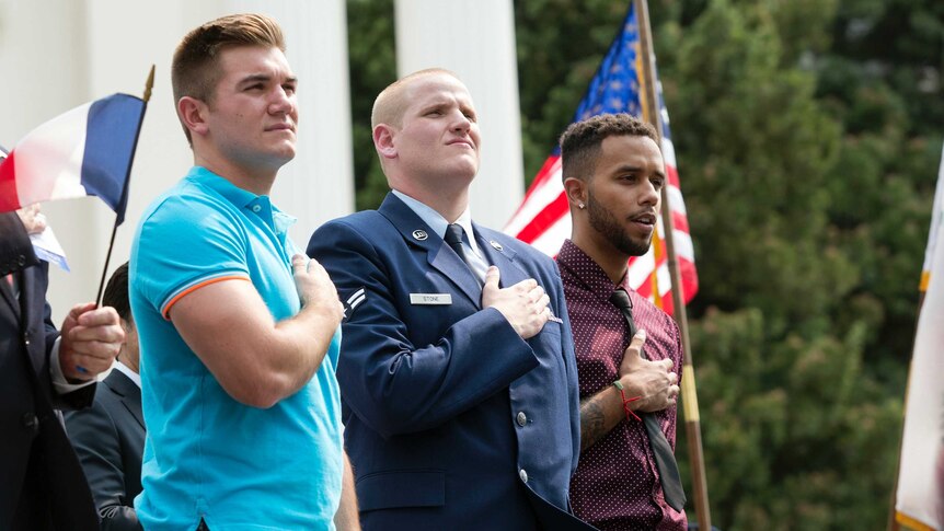 The three men are at a parade held to honour their heroic actions to stop a gunman on a train.