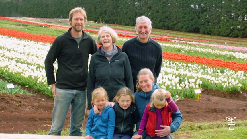 Family standing in paddock filled with coloured tulips