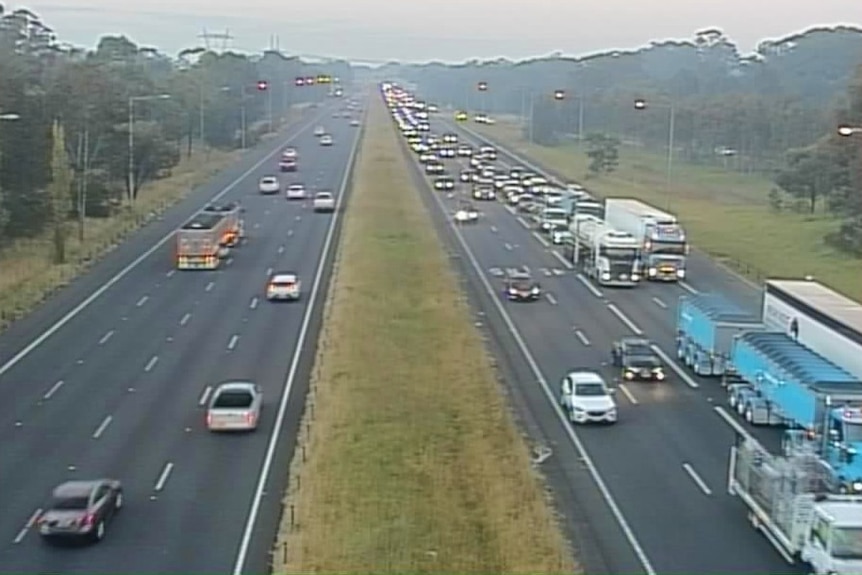 Several lanes of a road with cars on it.