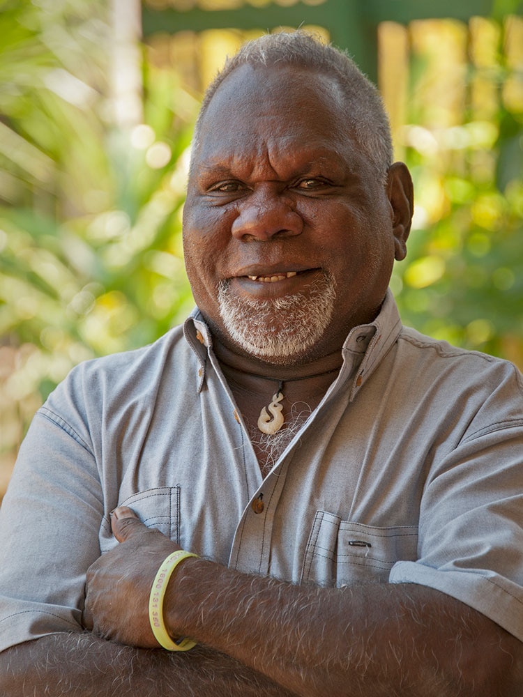 Man smiling arms folded for corporate headshot.