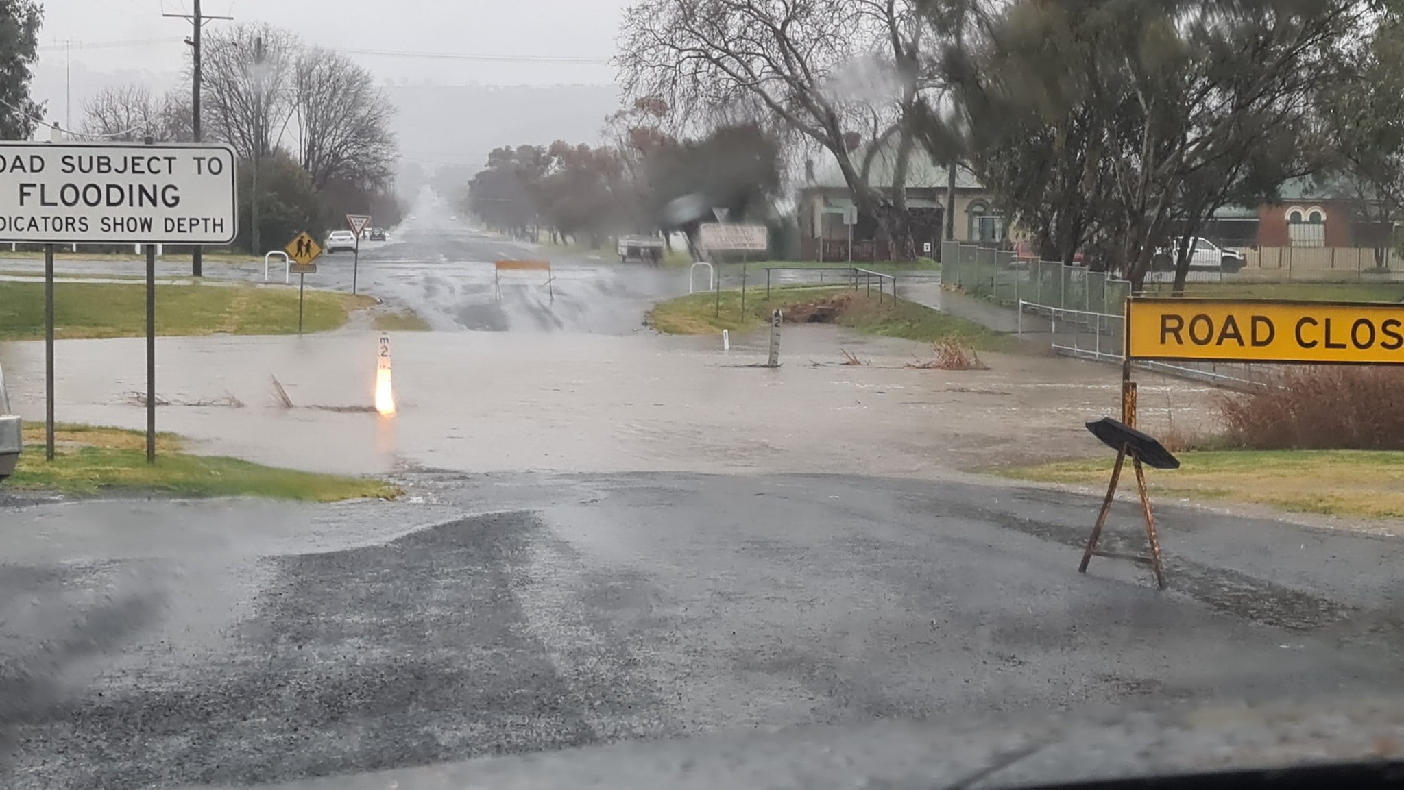 Warning signs sit near a flooded road.