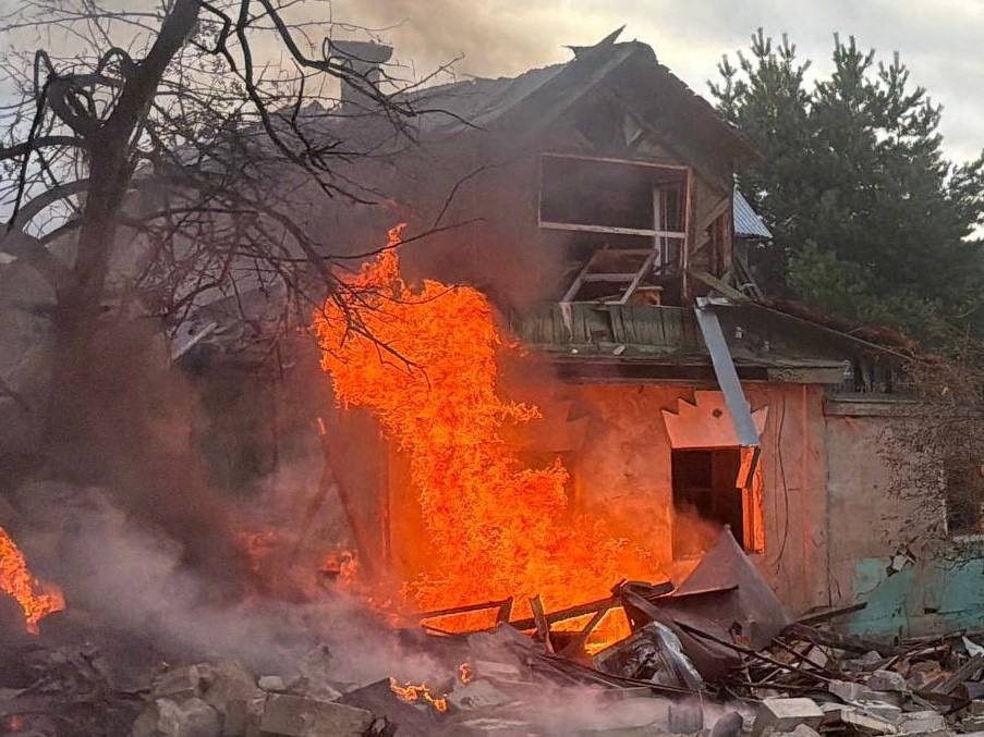 A house falling apart with a big plume of fire.