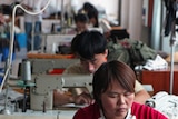 Chinese workers sew clothes at a garments factory