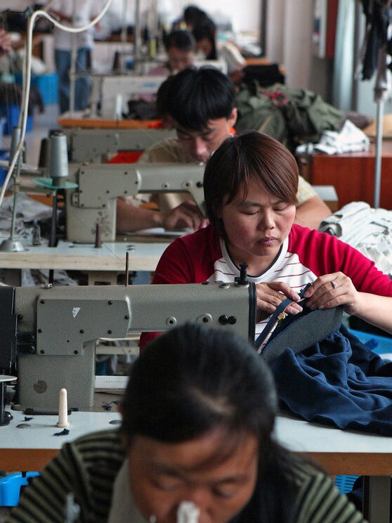 Chinese workers sew clothes at a garments factory in Shanghai
