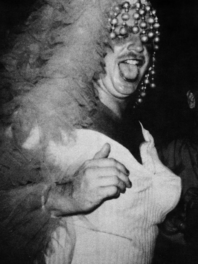 A black and white photo of a man in drag.