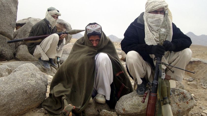 Taliban fighters squat next to their weapons in an undisclosed location in Afghanistan in October, 2009. (Reuters)