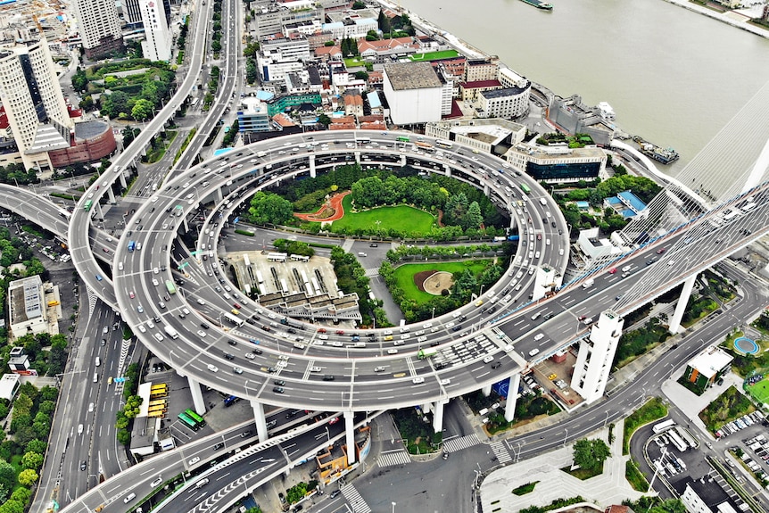 Una complicada red de autopistas con varios caminos que dan paso a una gran carretera circular y jardines verdes en el medio.