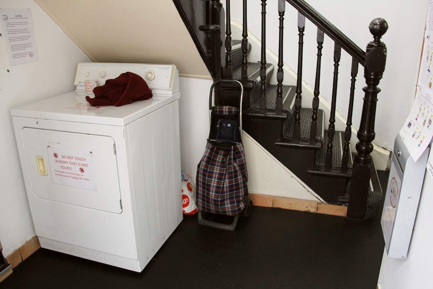 A washing machine crammed in below a staircase