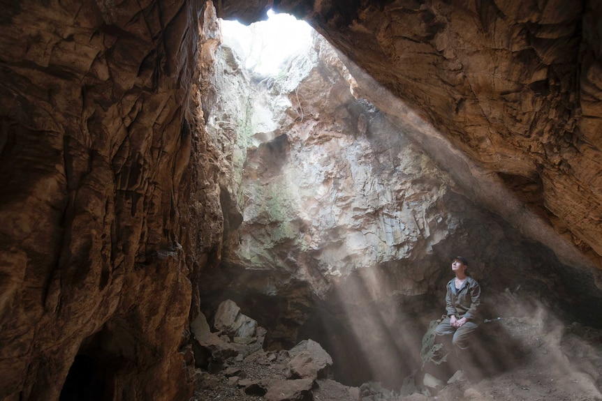 Underground Astronaut Marina Elliott in cave opening  Source: National Geographic