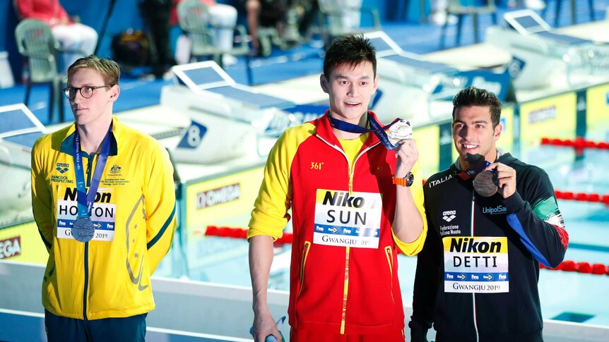 Sun Yang holding his medal while Mack Horton looks away